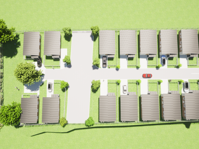 An aerial view of a residential housing development showing the layout of multiple units, access roads, and surrounding green space.