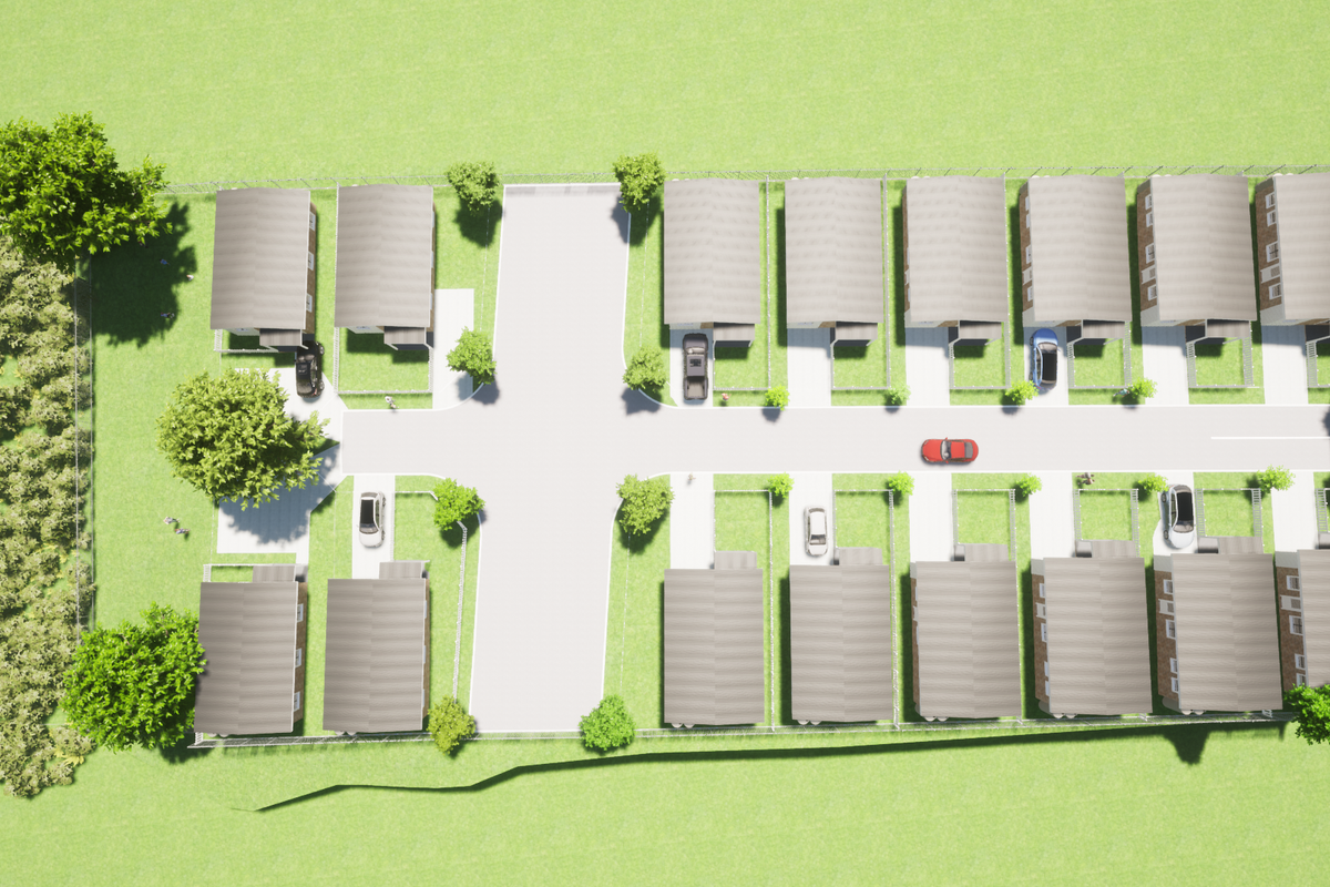 An aerial view of a residential housing development showing the layout of multiple units, access roads, and surrounding green space.