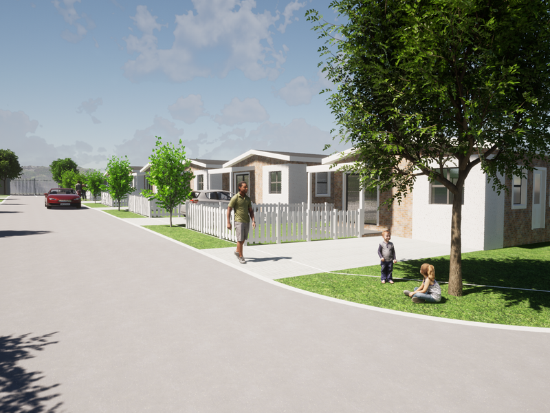 A street-level view of a residential development featuring modern single-story homes with brick facades, paved driveways, and picket fencing.
