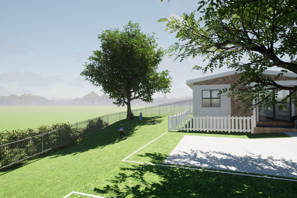 A modern residential exterior featuring a brick facade, paved driveway, and secure perimeter fencing set against a scenic mountain backdrop.