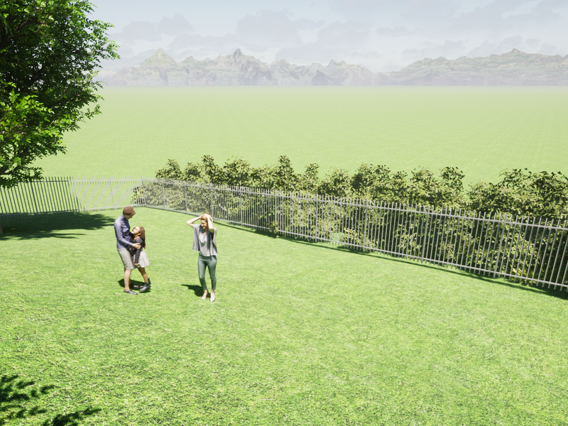A spacious garden area featuring a manicured lawn and secure metal perimeter fencing with scenic mountain views in the background.