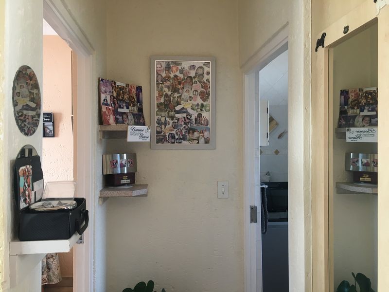 A functional hallway area featuring built-in corner shelving and access to adjacent rooms, providing a central circulation point within the apartment.