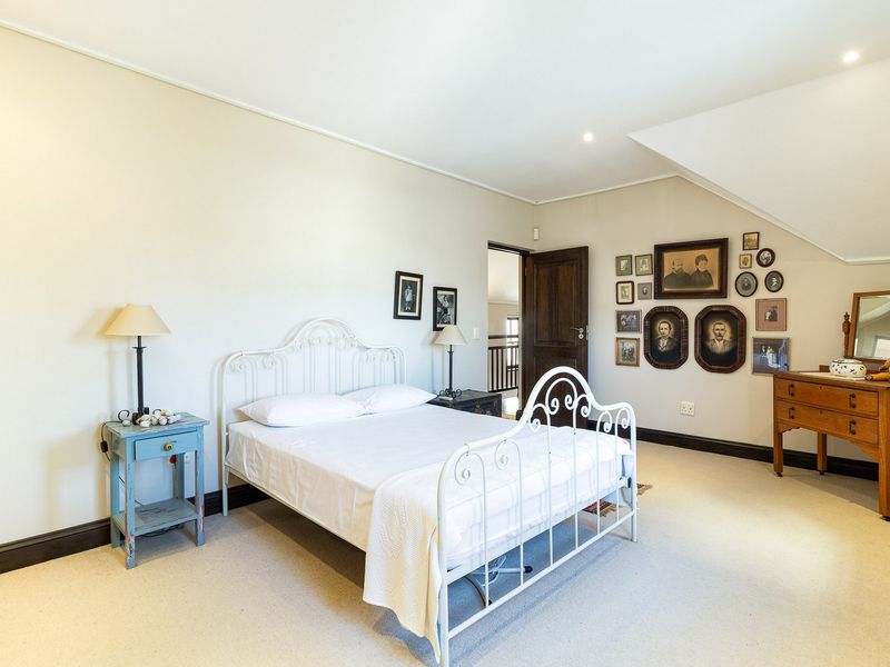 A spacious bedroom featuring neutral walls, carpeted flooring, and a sloped ceiling, providing a comfortable and well-maintained living space.