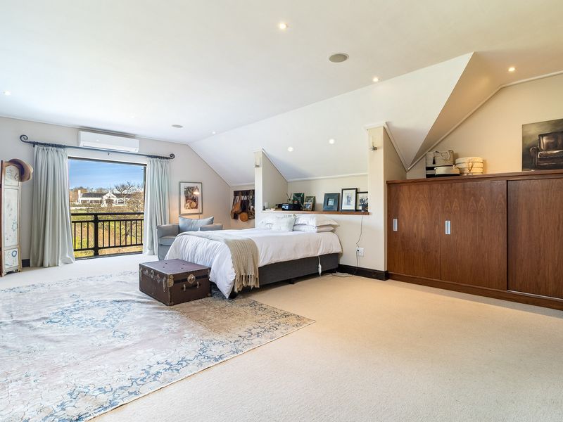 Spacious bedroom featuring a sloped ceiling, built-in cabinetry, recessed lighting, and direct access to a private balcony with scenic views.