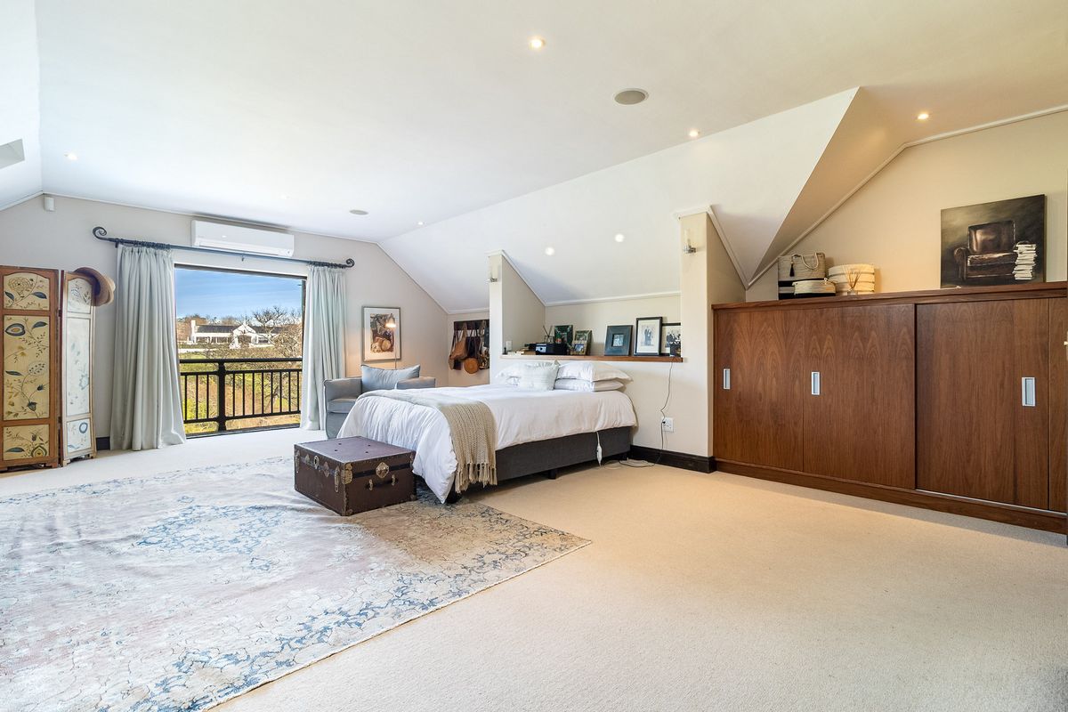 Spacious bedroom featuring a sloped ceiling, built-in cabinetry, recessed lighting, and direct access to a private balcony with scenic views.
