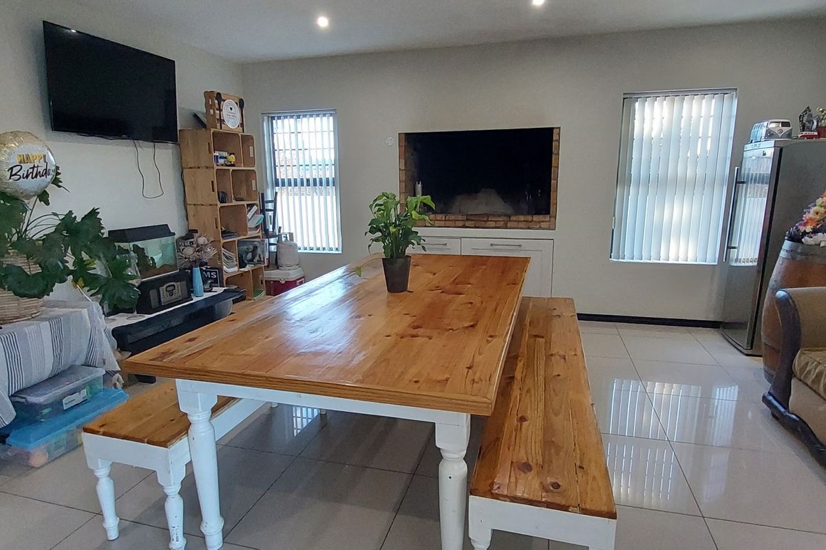 Spacious living area featuring tiled flooring, recessed downlights, and a built-in fireplace, offering a versatile space for dining and relaxation.