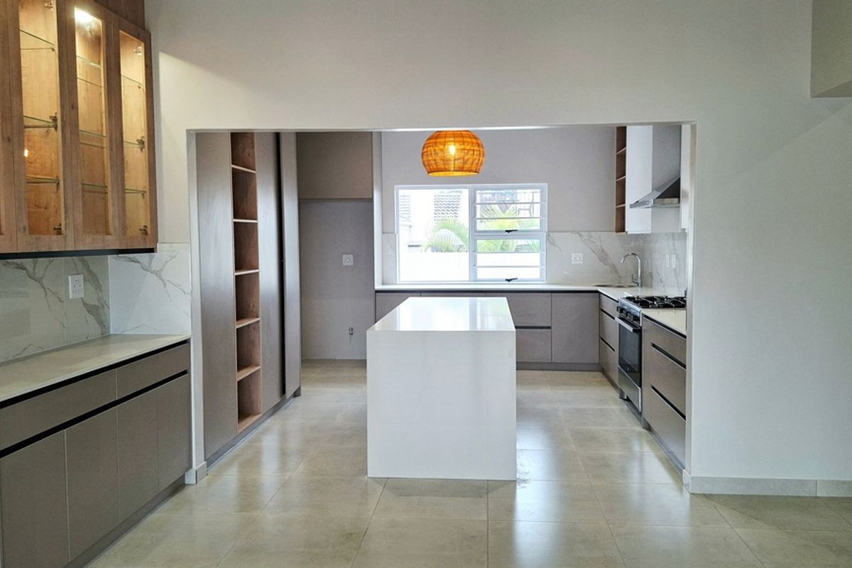 Modern, spacious kitchen featuring a central island, sleek cabinetry, stone countertops, integrated appliances, and high-quality finishes throughout.