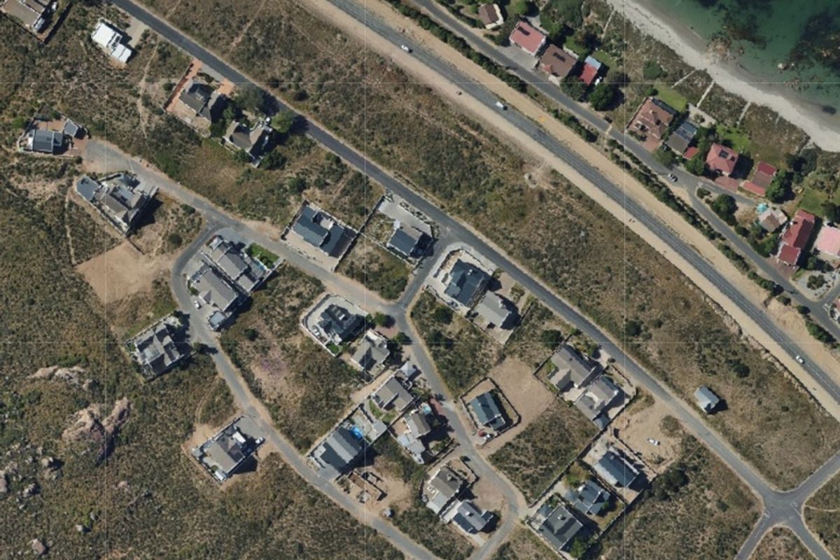 An aerial view of a residential coastal estate showing the layout of properties, road infrastructure, and proximity to the coastline.