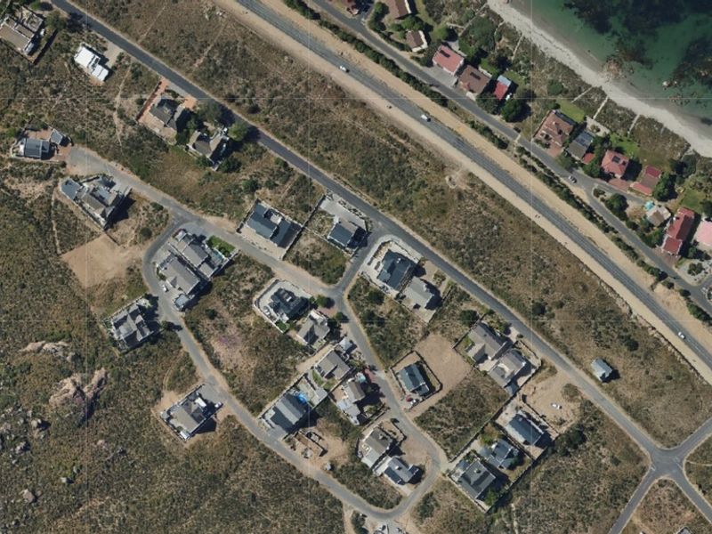 An aerial view of a residential coastal estate showing the layout of properties, road infrastructure, and proximity to the coastline.