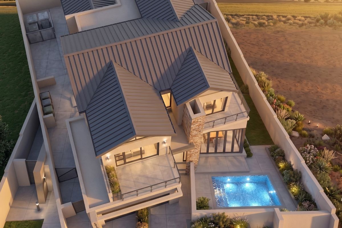 Aerial view of a modern residential property featuring a metal roof, private swimming pool, stone accents, and landscaped outdoor areas at sunset.