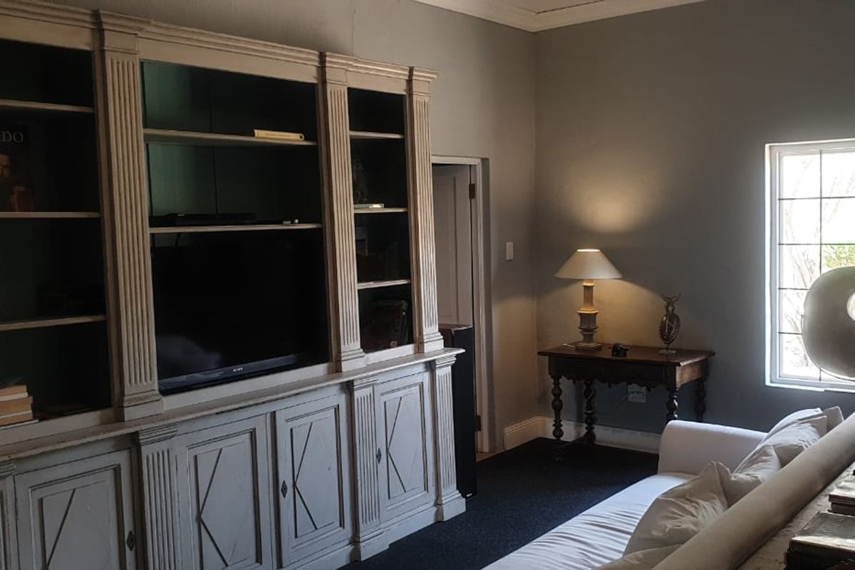 A cozy living room featuring classic built-in cabinetry and natural light from a large window.