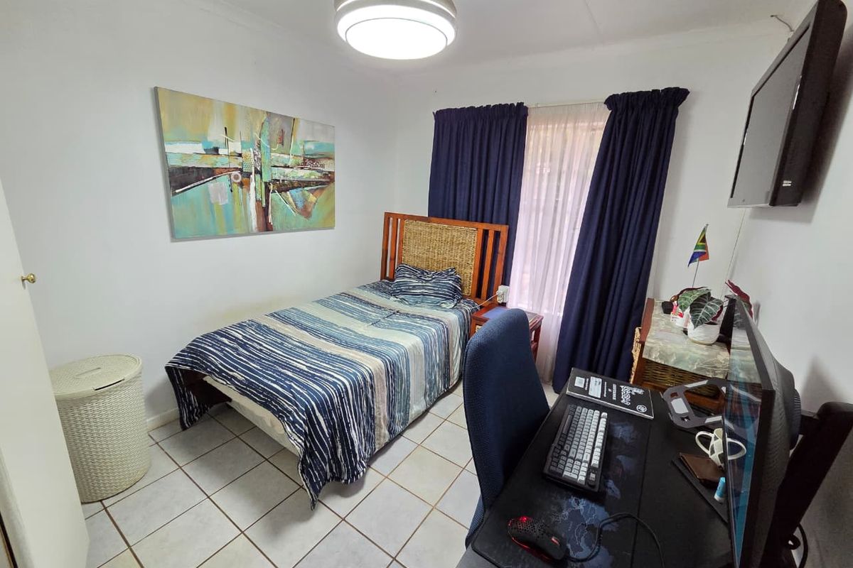 A functional bedroom featuring tiled flooring and a central ceiling light fixture, providing a practical space for rest or study.