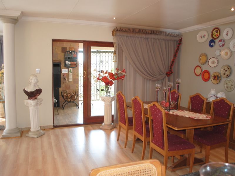 Dining room featuring laminate flooring, a structural column, and a sliding glass door providing access to an outdoor area.