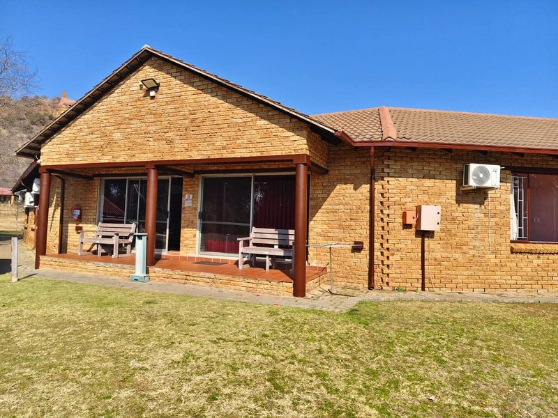 Rear view of a face brick small holding dwelling featuring a covered patio, sliding door access, and an installed air conditioning unit.