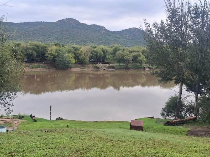 A scenic view overlooking a river with lush green banks and mountain vistas in the background, highlighting the property's natural landscape.