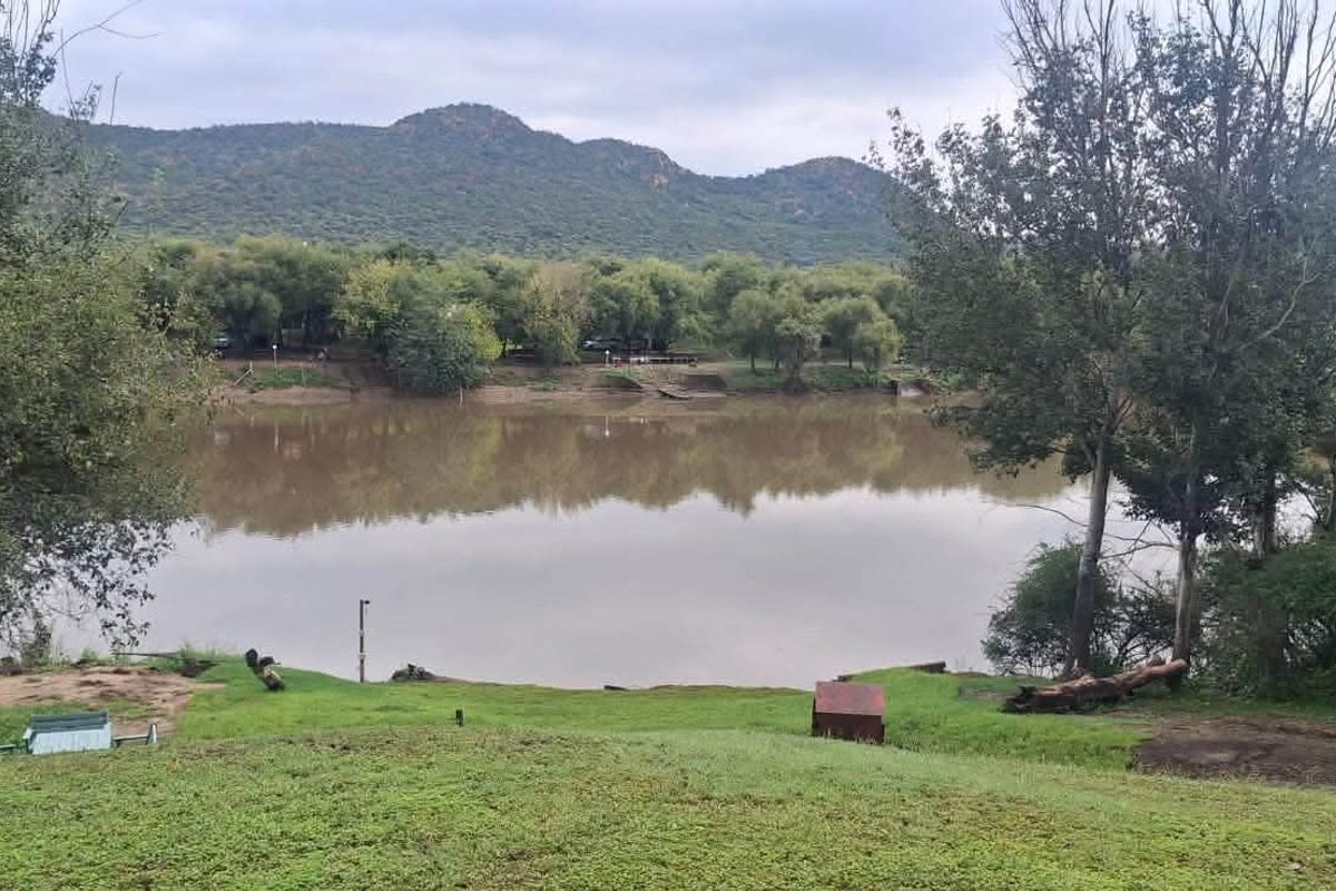 A scenic view overlooking a river with lush green banks and mountain vistas in the background, highlighting the property's natural landscape.