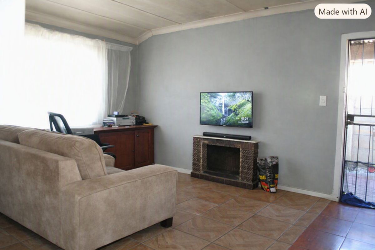 A living room featuring tiled flooring and a built-in fireplace, with direct access to an exterior area through a security gate.