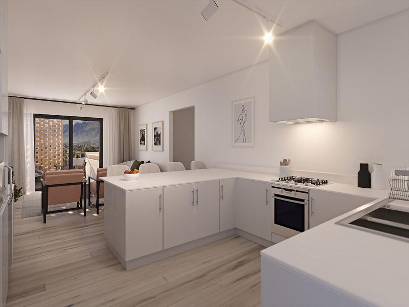 Modern open-plan kitchen and living area featuring sleek cabinetry, integrated appliances, and sliding doors leading to a balcony with mountain views.