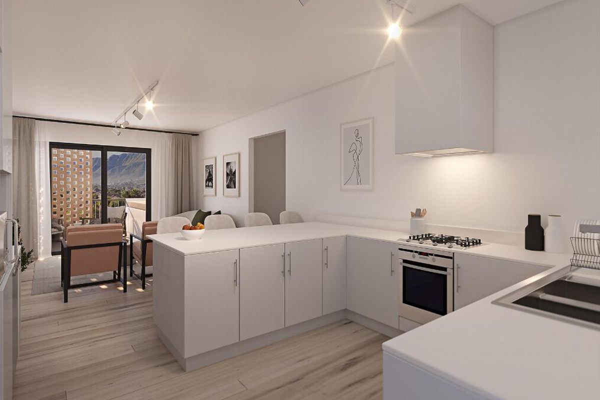 Modern open-plan kitchen and living area featuring sleek cabinetry, integrated appliances, and sliding doors leading to a balcony with mountain views.