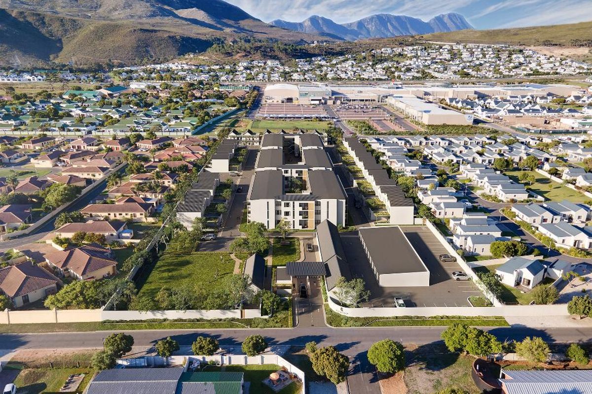 Aerial view of a modern apartment complex featuring landscaped grounds, secure gated access, and dedicated parking areas within a residential neighborhood.