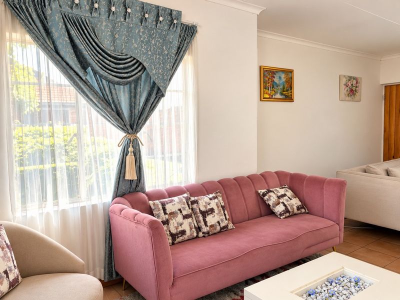 A comfortable living room featuring tiled flooring and coved ceilings, offering a bright and inviting space for relaxation.
