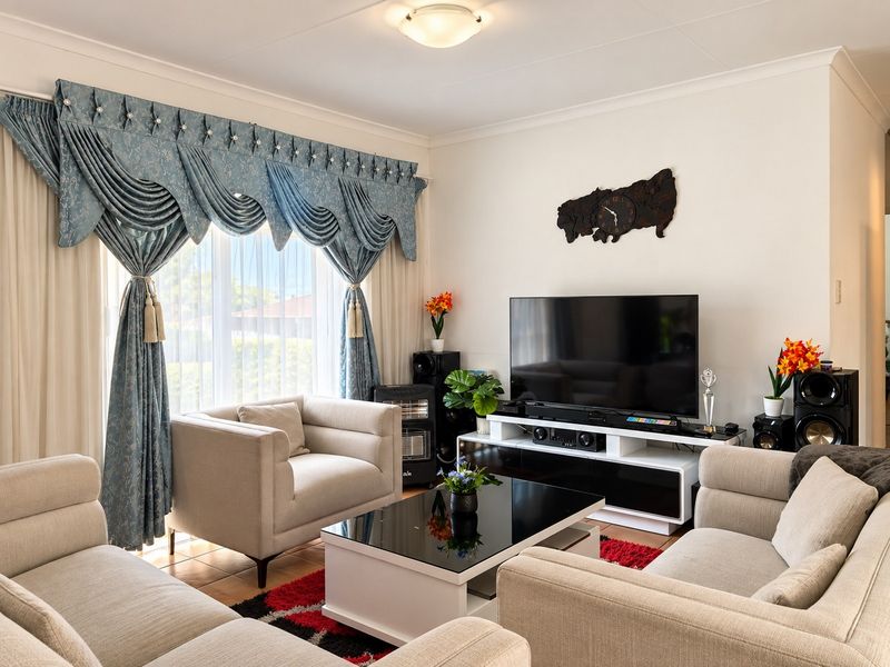 A well-maintained living room featuring tiled flooring and decorative coving, providing a comfortable and functional space for relaxation.