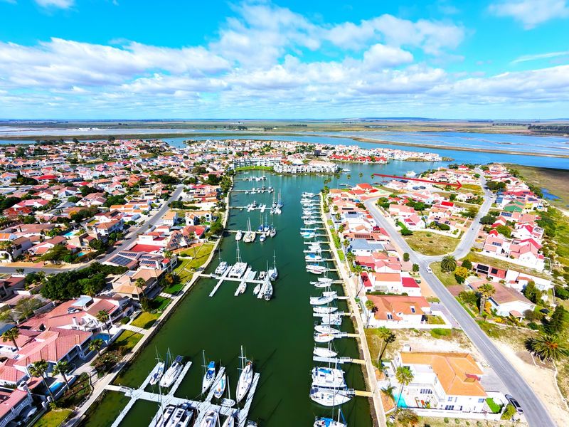 Aerial view of a residential marina estate featuring waterfront properties, private boat moorings, and surrounding landscape.
