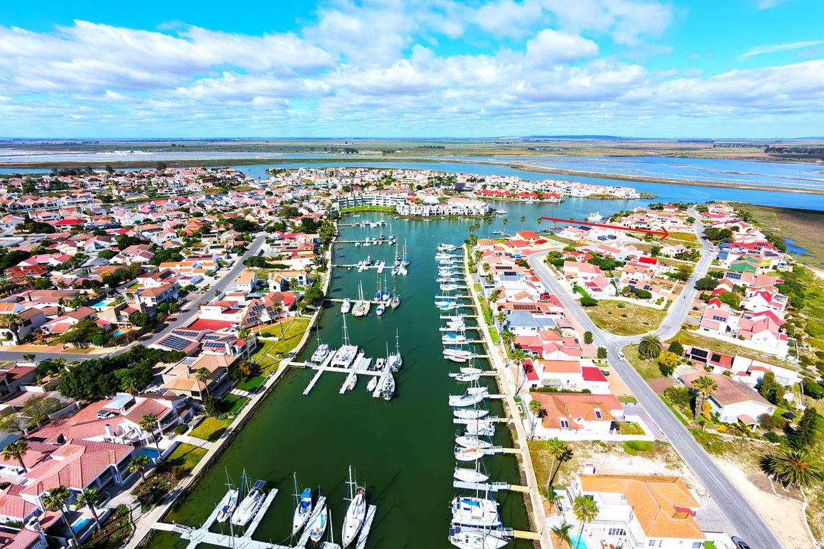 Aerial view of a residential marina estate featuring waterfront properties, private boat moorings, and surrounding landscape.