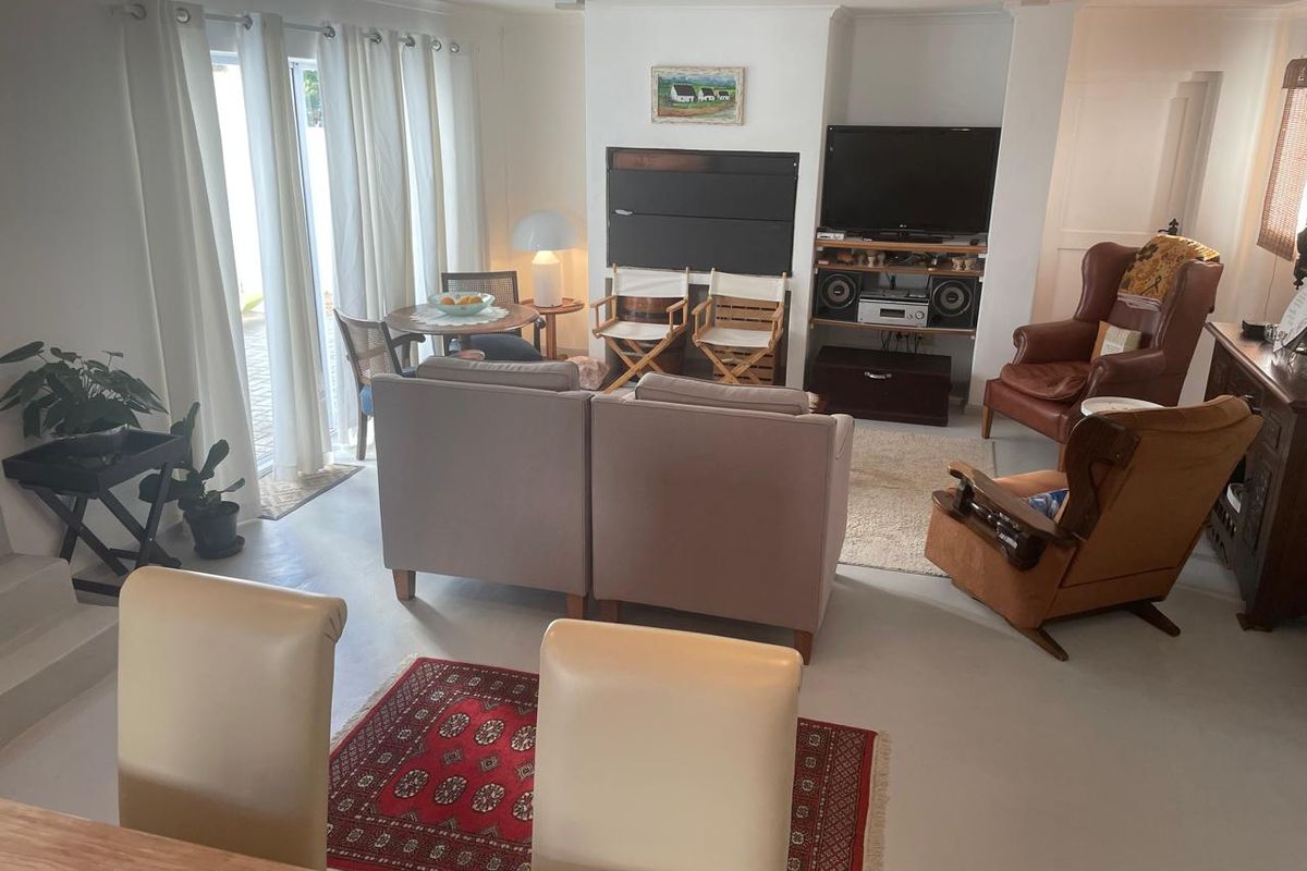 A spacious living room featuring concrete flooring, recessed shelving, and large sliding glass doors that provide ample natural light and access to the outdoors.