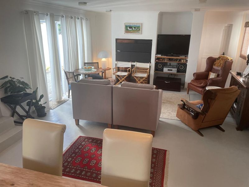 A spacious living room featuring concrete flooring, recessed shelving, and large sliding glass doors that provide ample natural light and access to the outdoors.