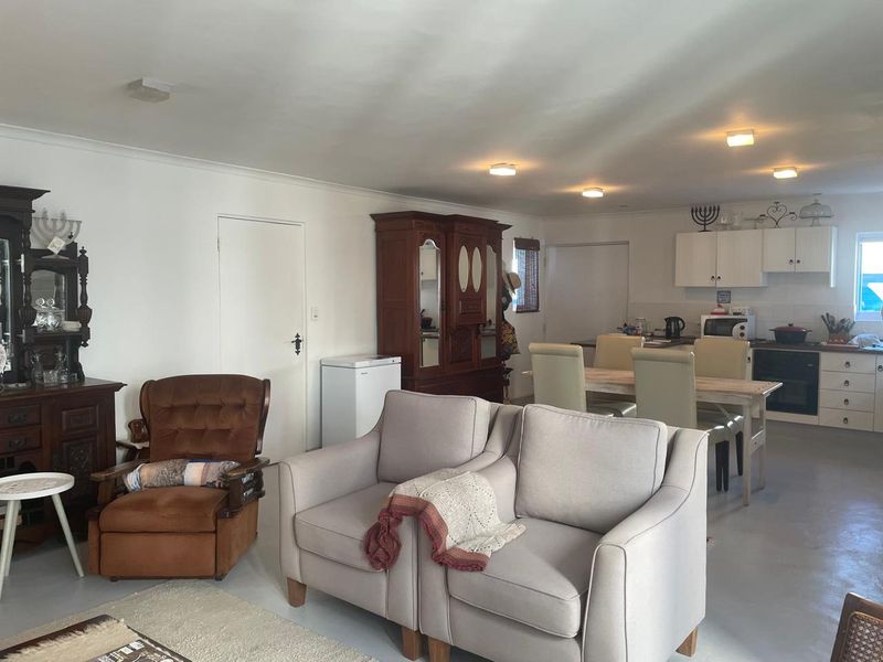 Open plan living and dining area featuring a functional kitchen with built-in cabinetry and integrated appliances, offering a versatile layout for modern living.