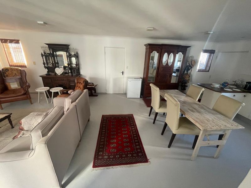 Spacious open-plan living and dining area featuring neutral tiled flooring and ample natural light, providing a versatile layout for modern family living.