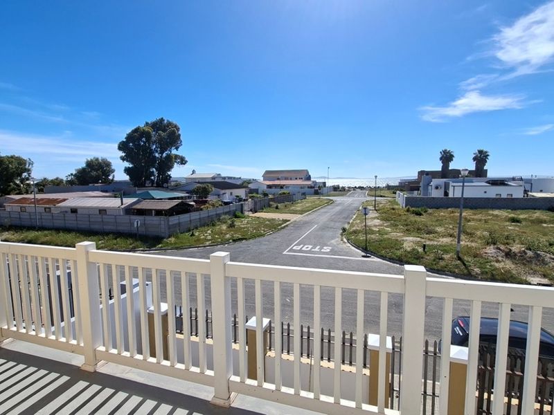 Elevated view overlooking the surrounding residential neighbourhood and street from a balcony with a white railing.
