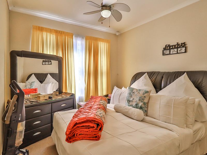 A standard bedroom featuring a ceiling fan and neutral wall finishes, providing a comfortable and functional sleeping space.
