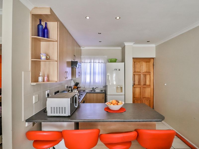 A functional kitchen featuring built-in cabinetry, laminate countertops, a breakfast bar, and recessed lighting, providing a practical space for cooking and casual dining.