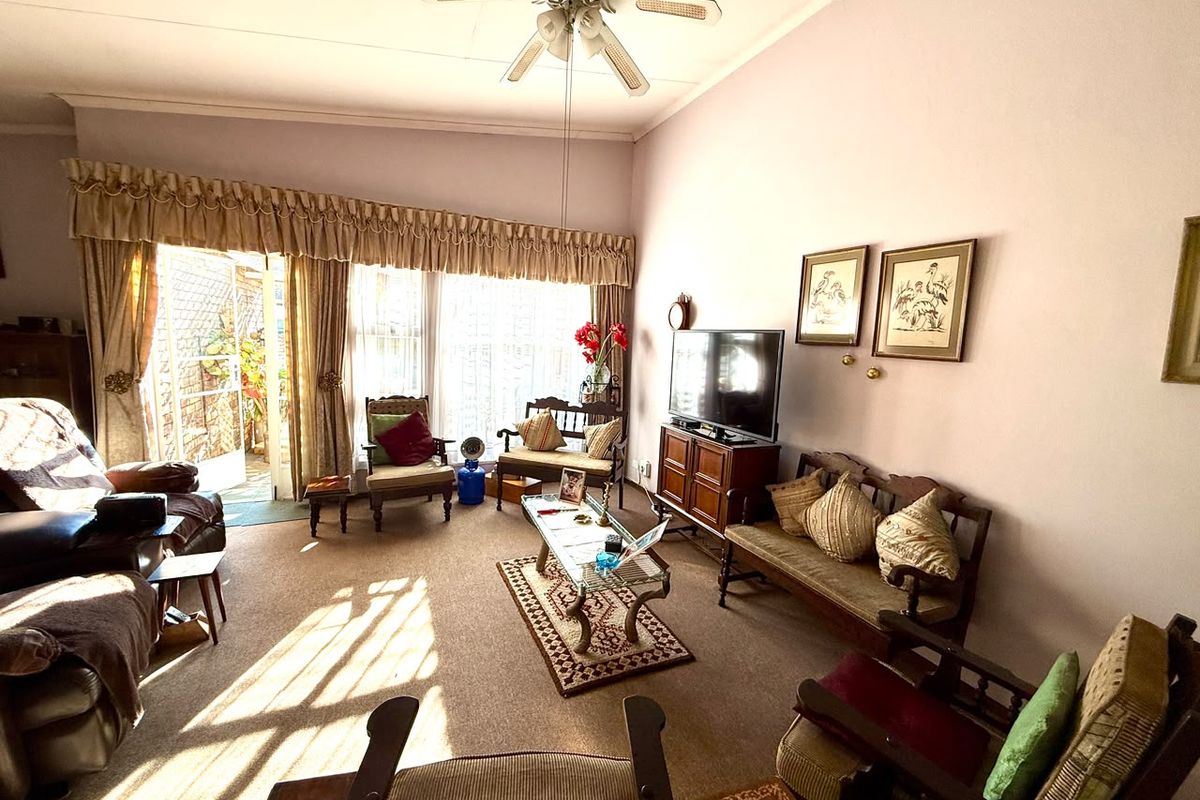 A spacious living room featuring a ceiling fan and large sliding glass doors that provide access to the outdoor area.