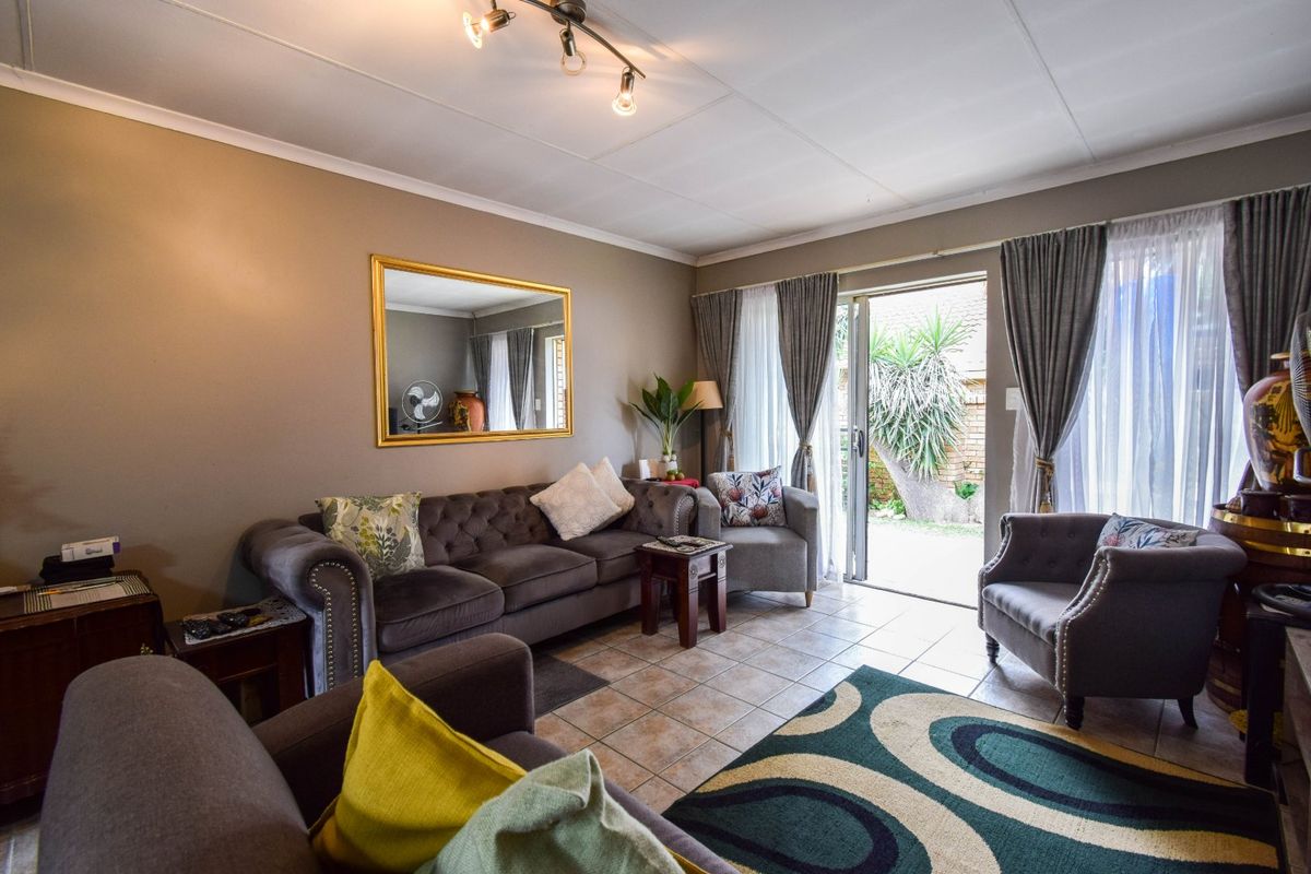 A comfortable living room featuring tiled flooring and a sliding glass door that provides direct access to the outdoor patio area.