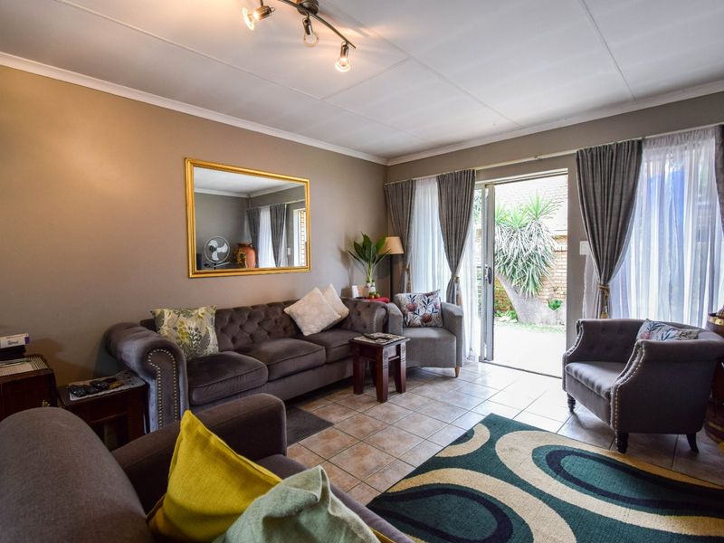 A comfortable living room featuring tiled flooring and a sliding glass door that provides direct access to the outdoor patio area.