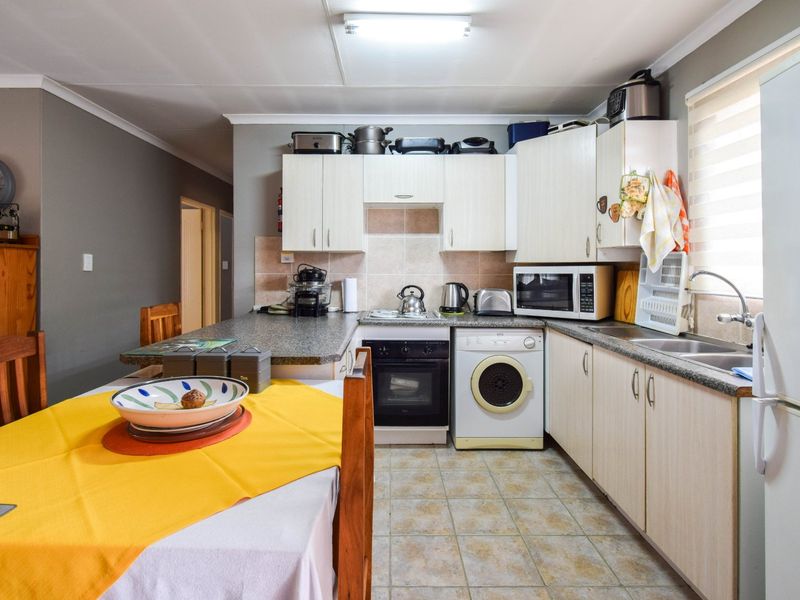 A functional kitchen featuring built-in cabinetry, laminate countertops, a built-in oven and hob, and tiled flooring with a practical layout.