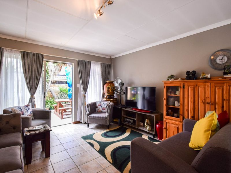 A comfortable living room featuring tiled flooring and a sliding glass door that provides direct access to the outdoor patio area.