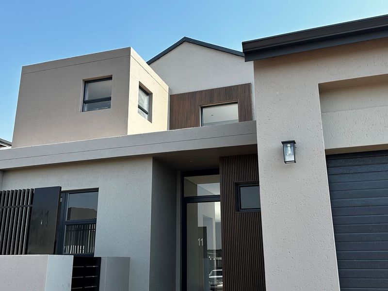 Modern double-storey residential facade featuring clean lines, timber slat accents, and a contemporary neutral finish.