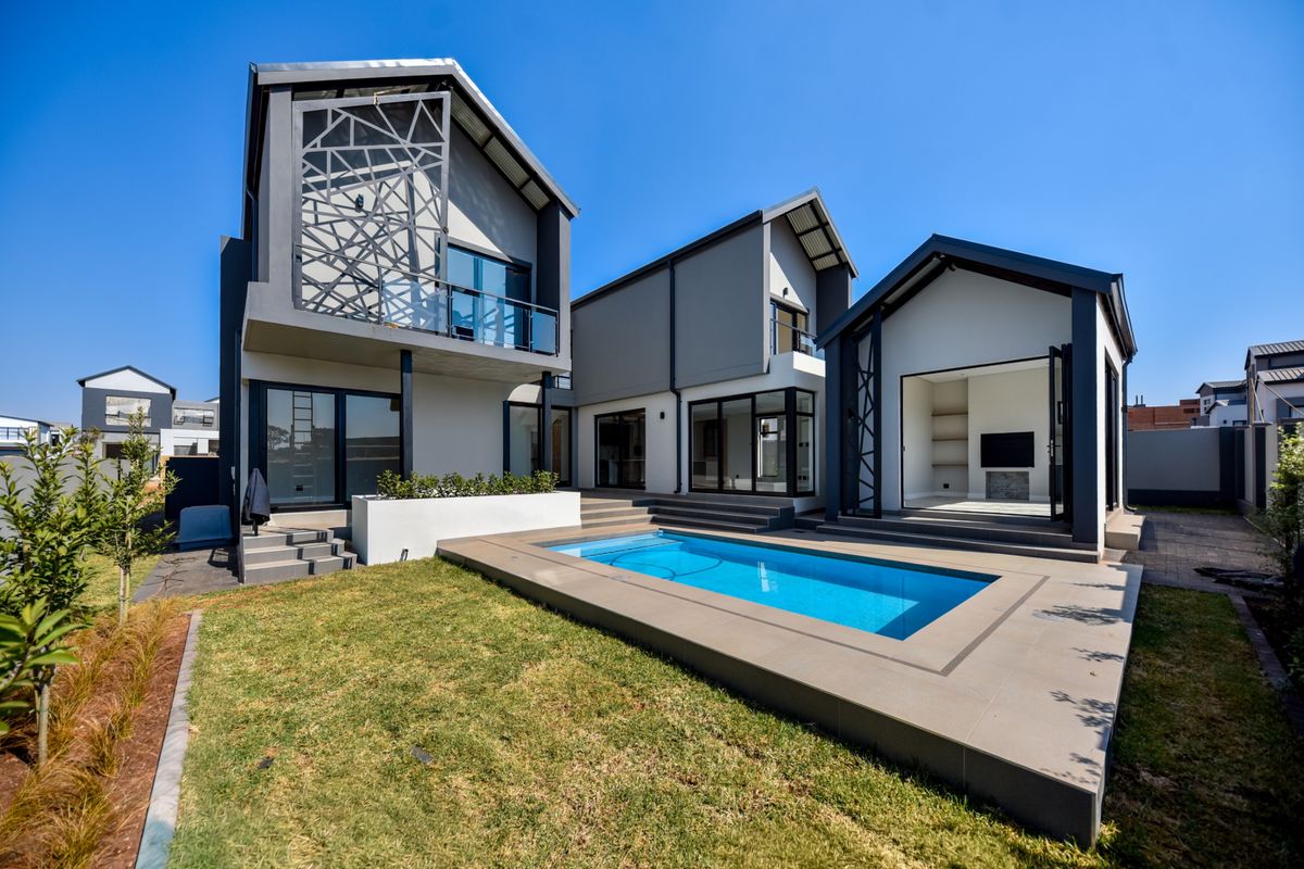 Modern rear exterior view featuring a swimming pool, tiled patio area, and contemporary architectural design with large glass sliding doors.