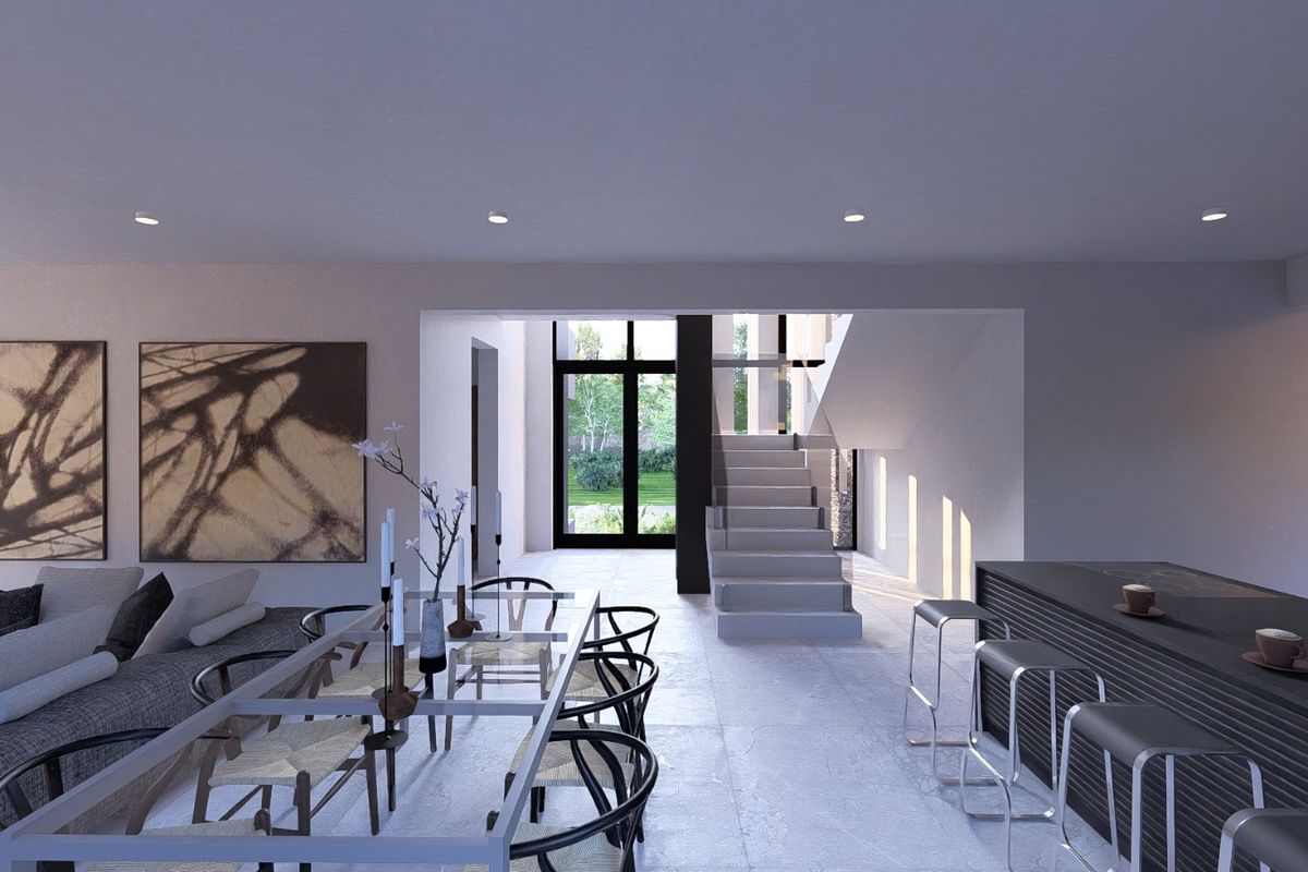 Modern open-plan living and dining area featuring a sleek kitchen island, stone flooring, and a central staircase leading to the upper level.