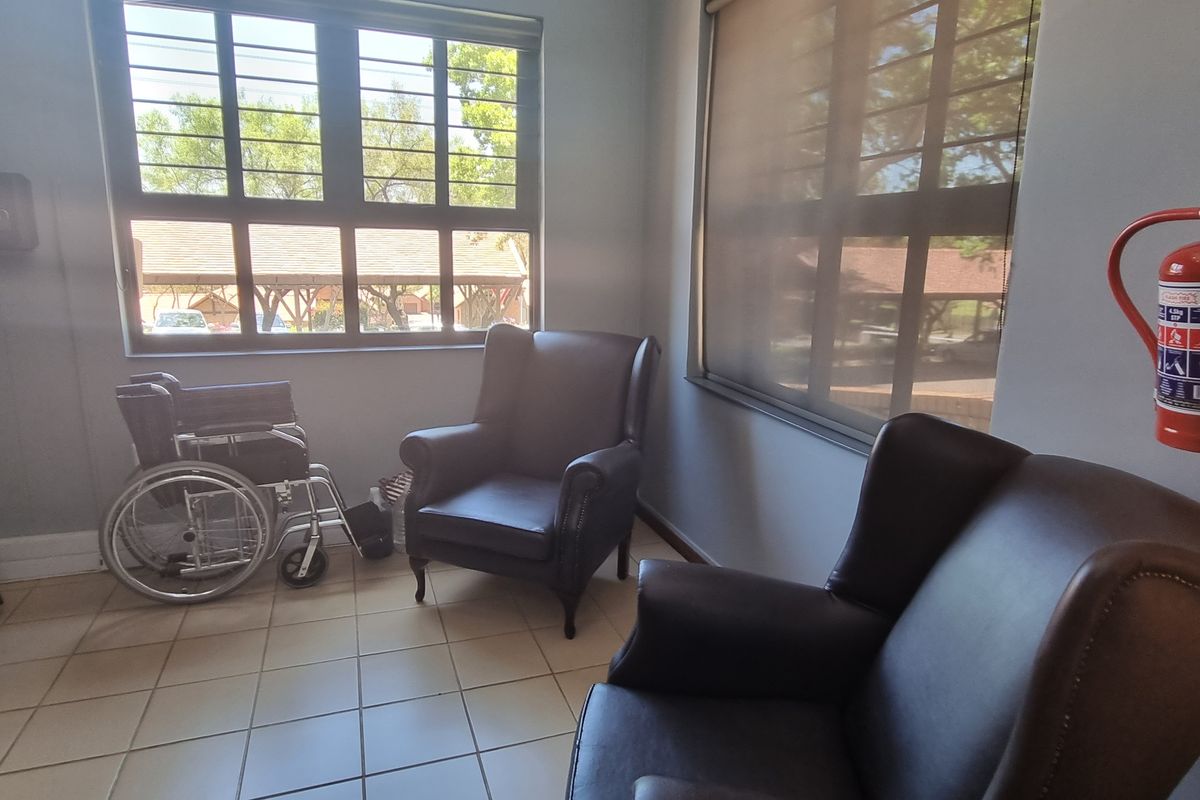 A functional seating area featuring tiled flooring, security bars on windows, and a wall-mounted fire extinguisher.
