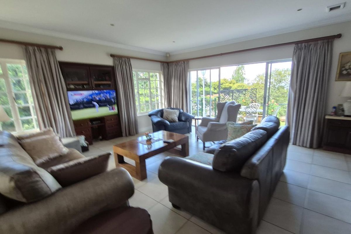Spacious living room featuring tiled flooring, built-in cabinetry, and large sliding glass doors that provide natural light and access to the outdoor area.