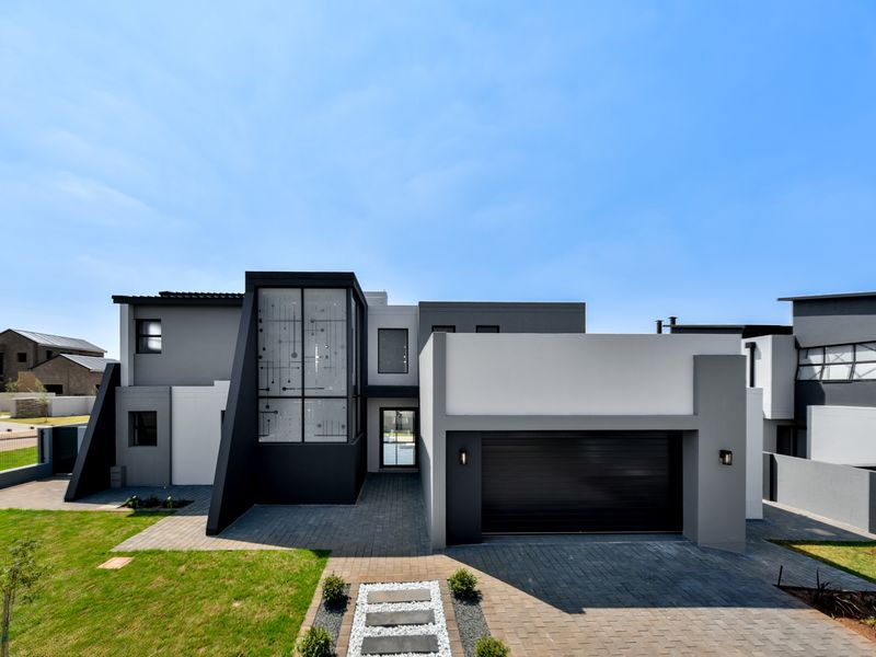 Modern double-story residential home featuring a contemporary facade, paved driveway, and integrated double garage.