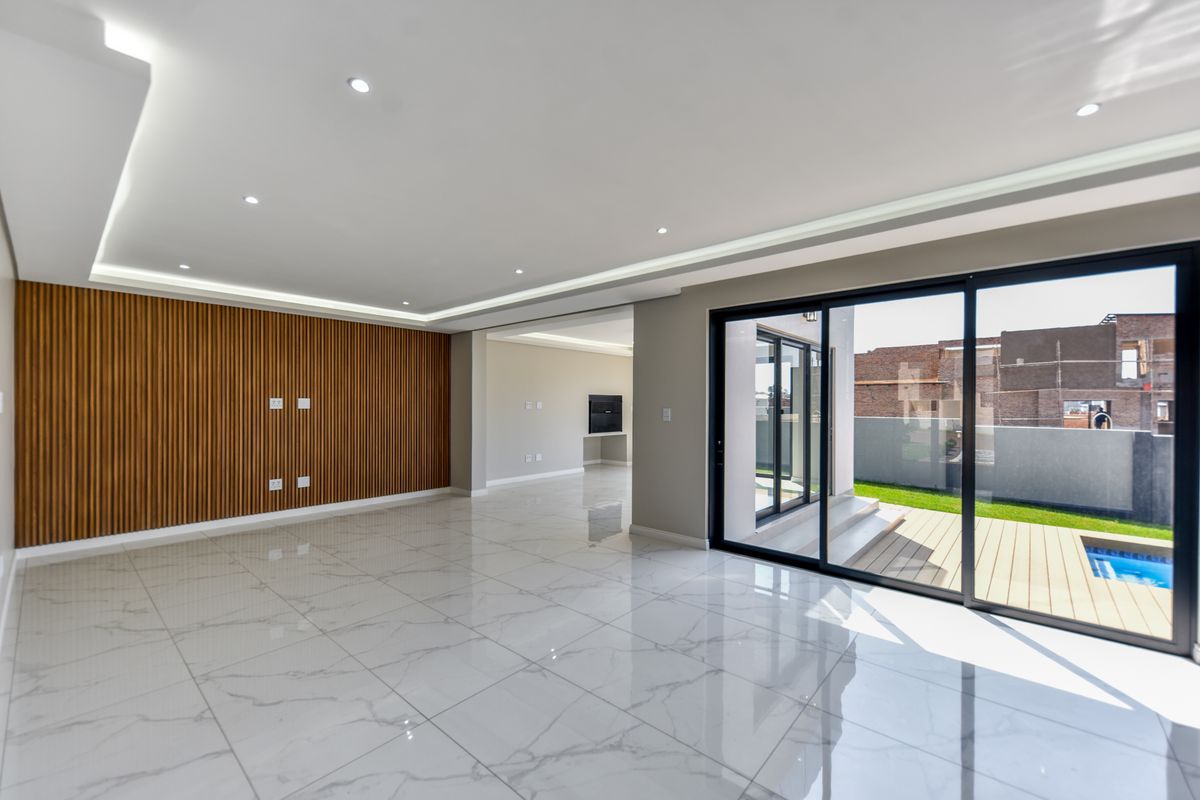 Spacious, modern living area featuring high-end marble-look floor tiles, elegant timber slat wall paneling, and seamless access to the outdoor patio and pool area.