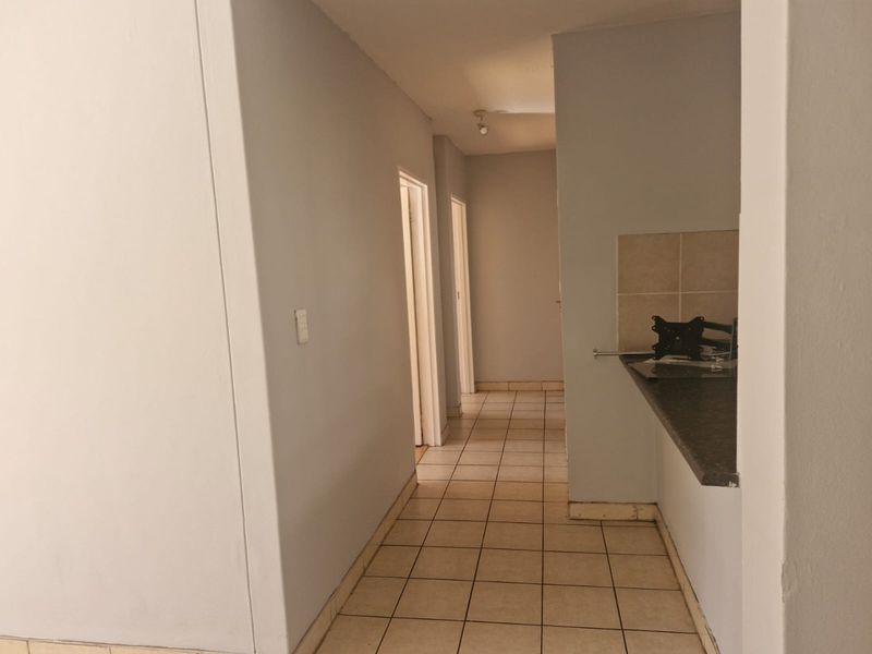 A functional hallway featuring tiled flooring and a breakfast bar counter, providing a clean transition between living spaces.