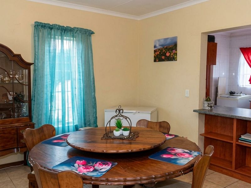 Open plan dining area featuring tiled flooring and coved ceilings, with a direct view into the adjacent kitchen space.