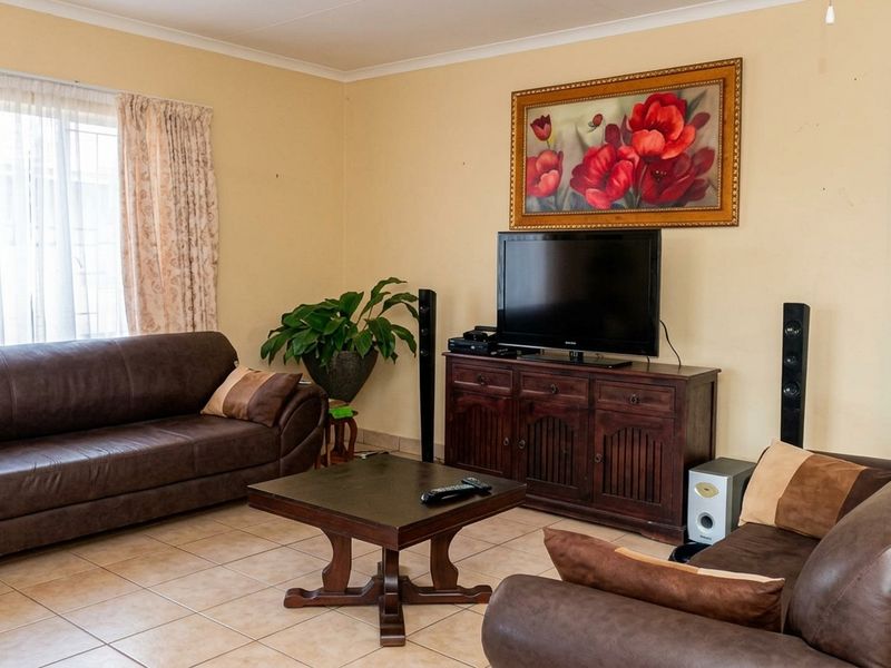 A comfortable living room featuring neutral wall tones and tiled flooring, providing a functional space for relaxation and entertainment.